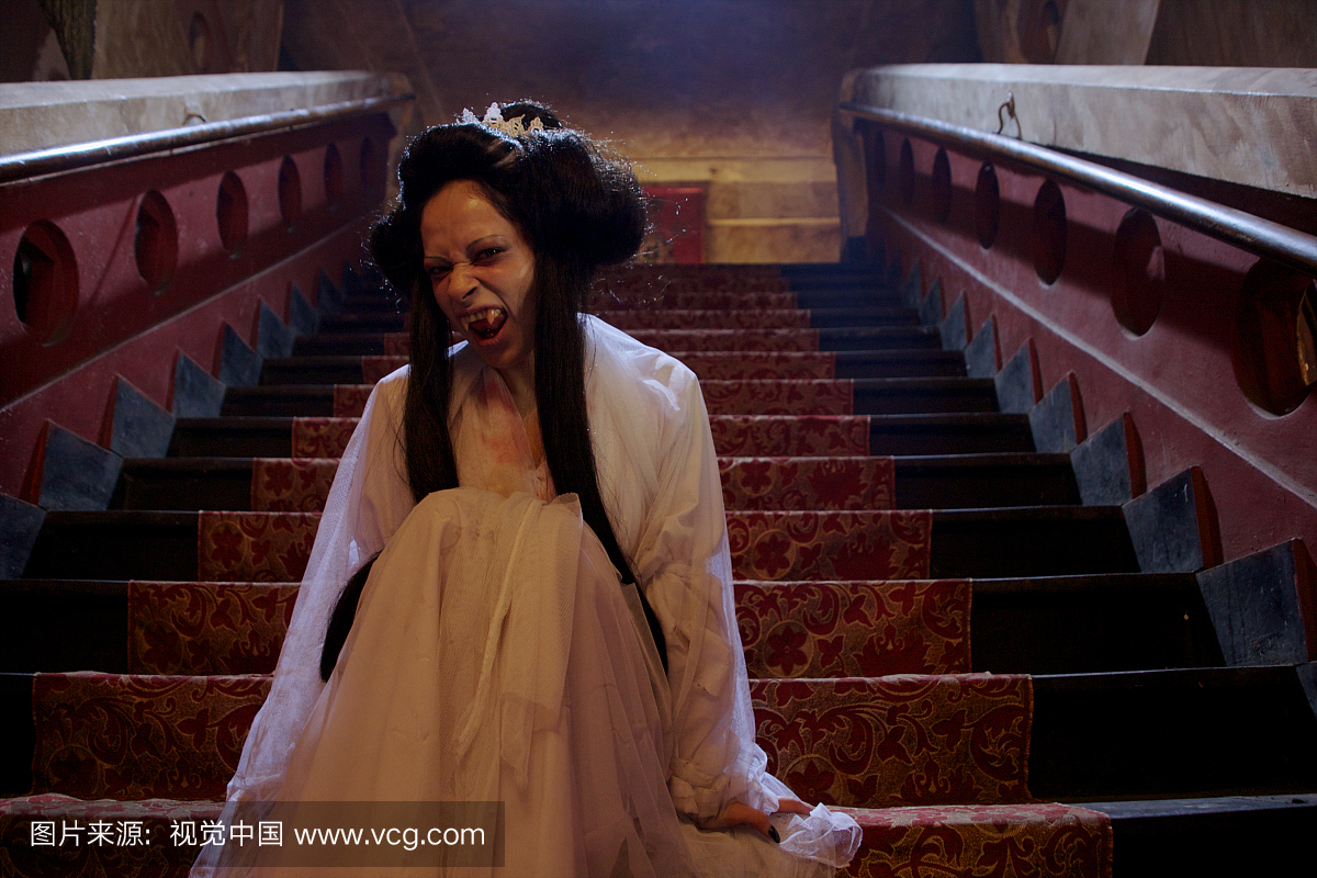 一个吸血鬼新娘坐在城堡里的一座staicase