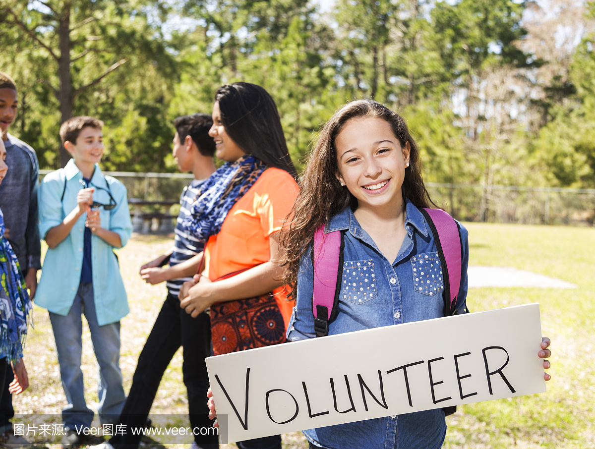 青少年拉丁女孩与朋友签署志愿者登录公园。