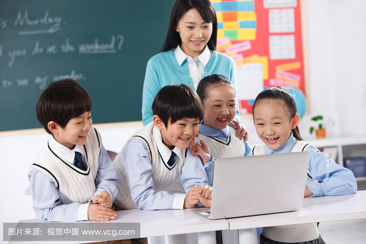 老师和小学生在教室里使用电脑