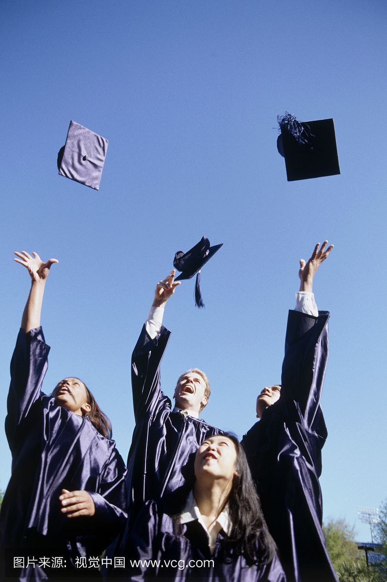oung graduates throwing their graduation caps 