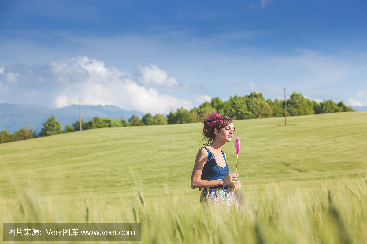 美丽的女人梦见棒棒糖在春天的田野