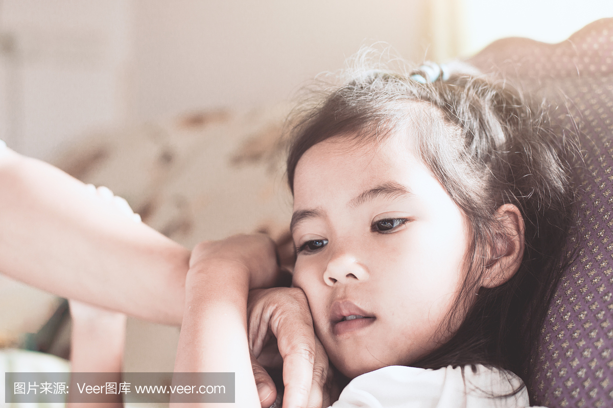 可爱的亚洲儿童女孩病和母亲的手触摸她的脸来