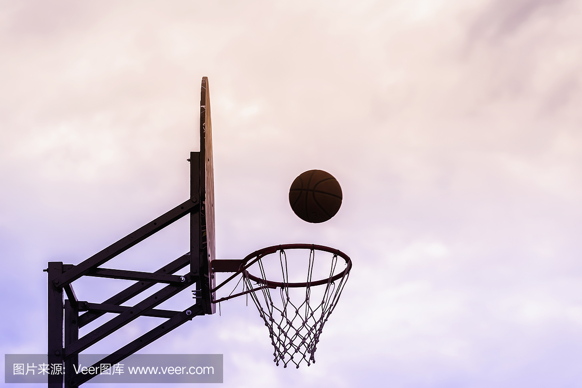 篮球盾,球飞到天空背景上的篮子的图形照片。