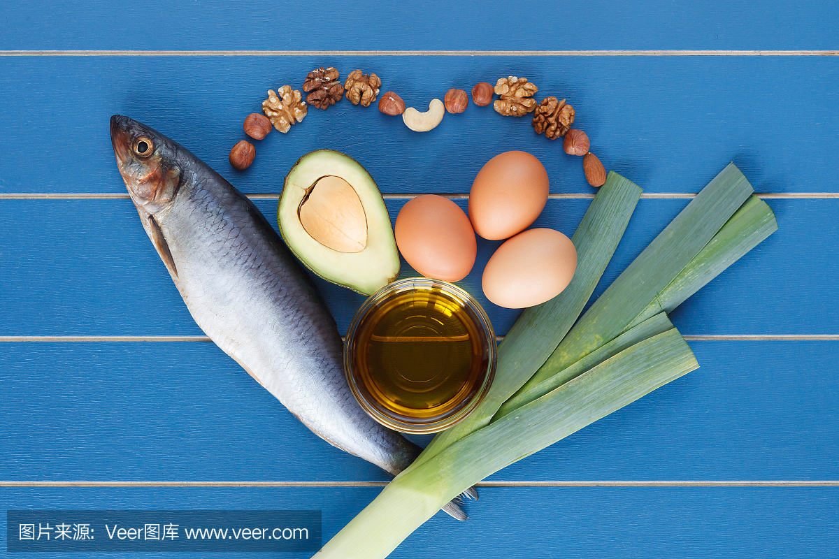 健康的心脏食物与鱼,鳄梨,鸡蛋,韭菜,橄榄油,坚