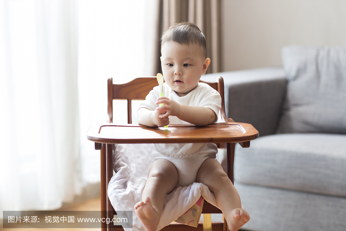 可爱的宝宝坐在儿童餐椅里