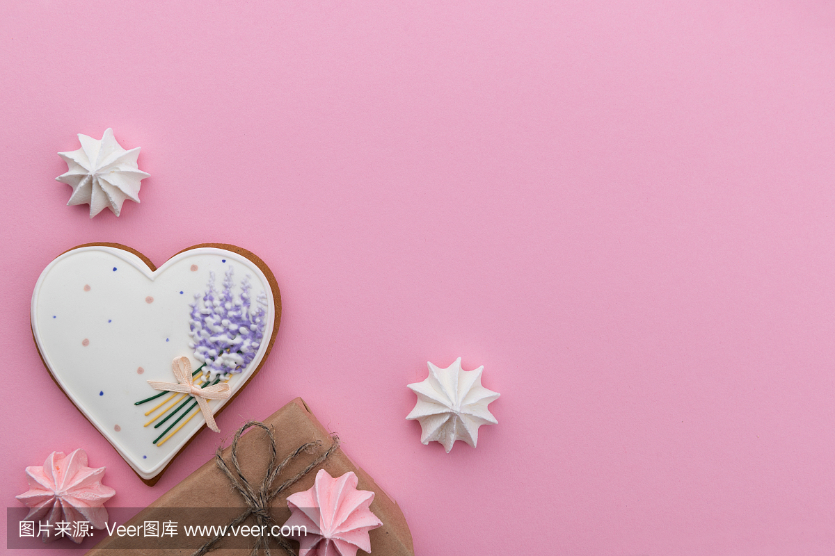 心形的饼干,棉花糖和粉红色的纸背景上的礼品