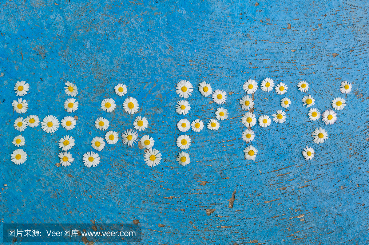 在蓝色背景上的雏菊花快乐写的单词