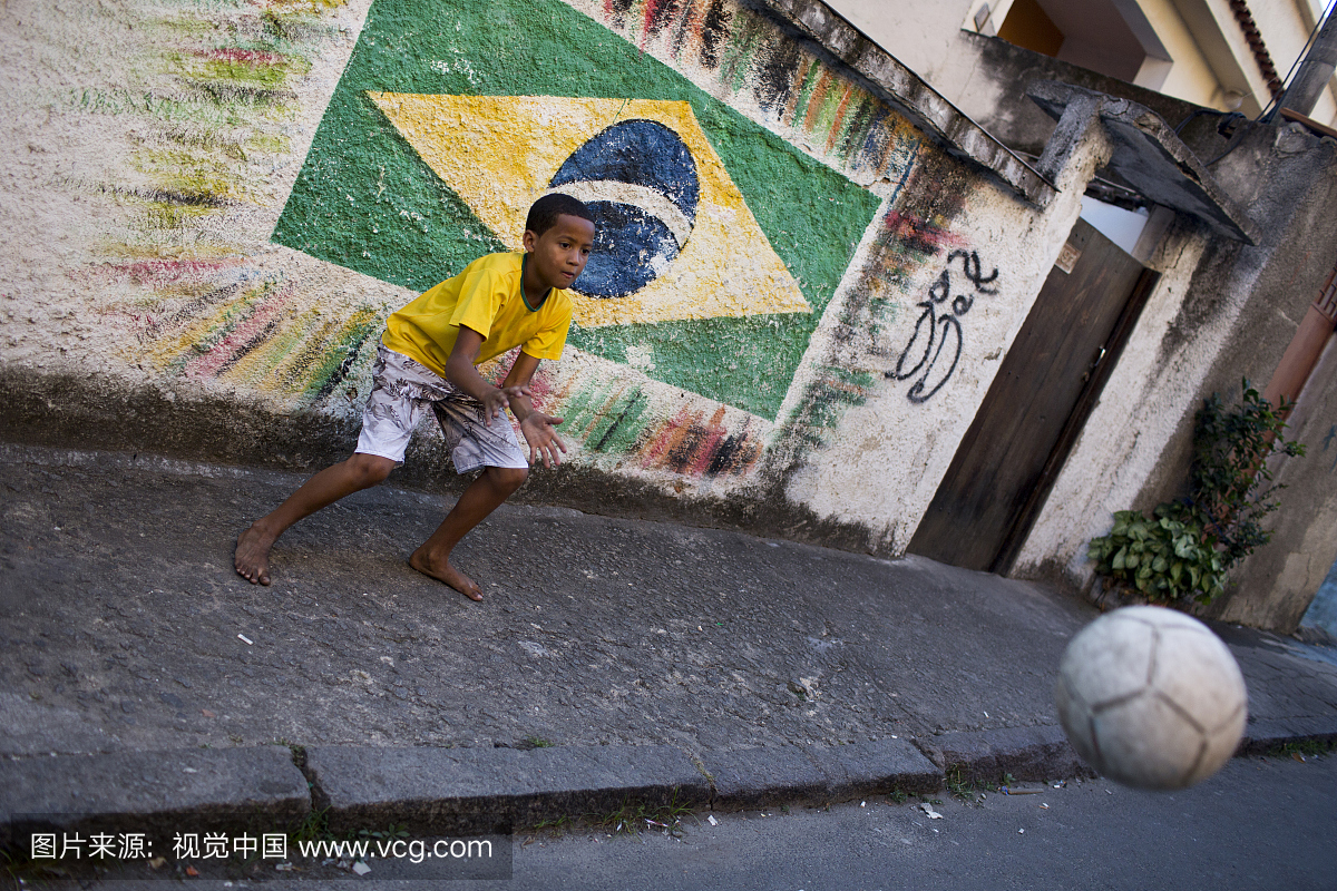 一名巴西男孩在街上踢足球
