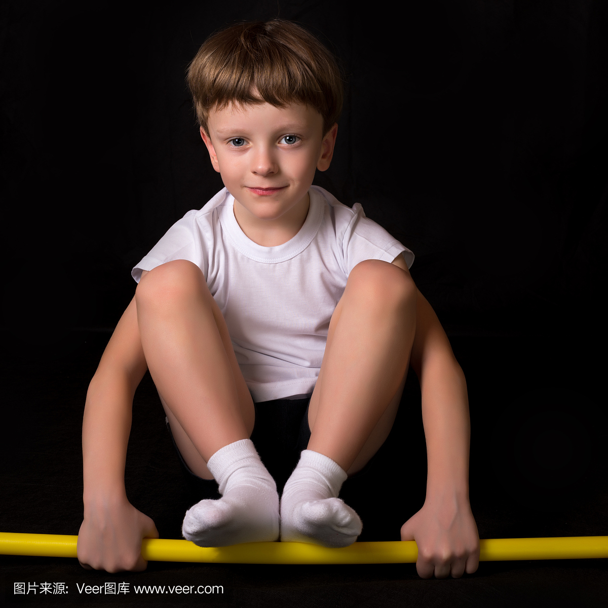 男孩运动员在健身房里用健身棒锻炼身体