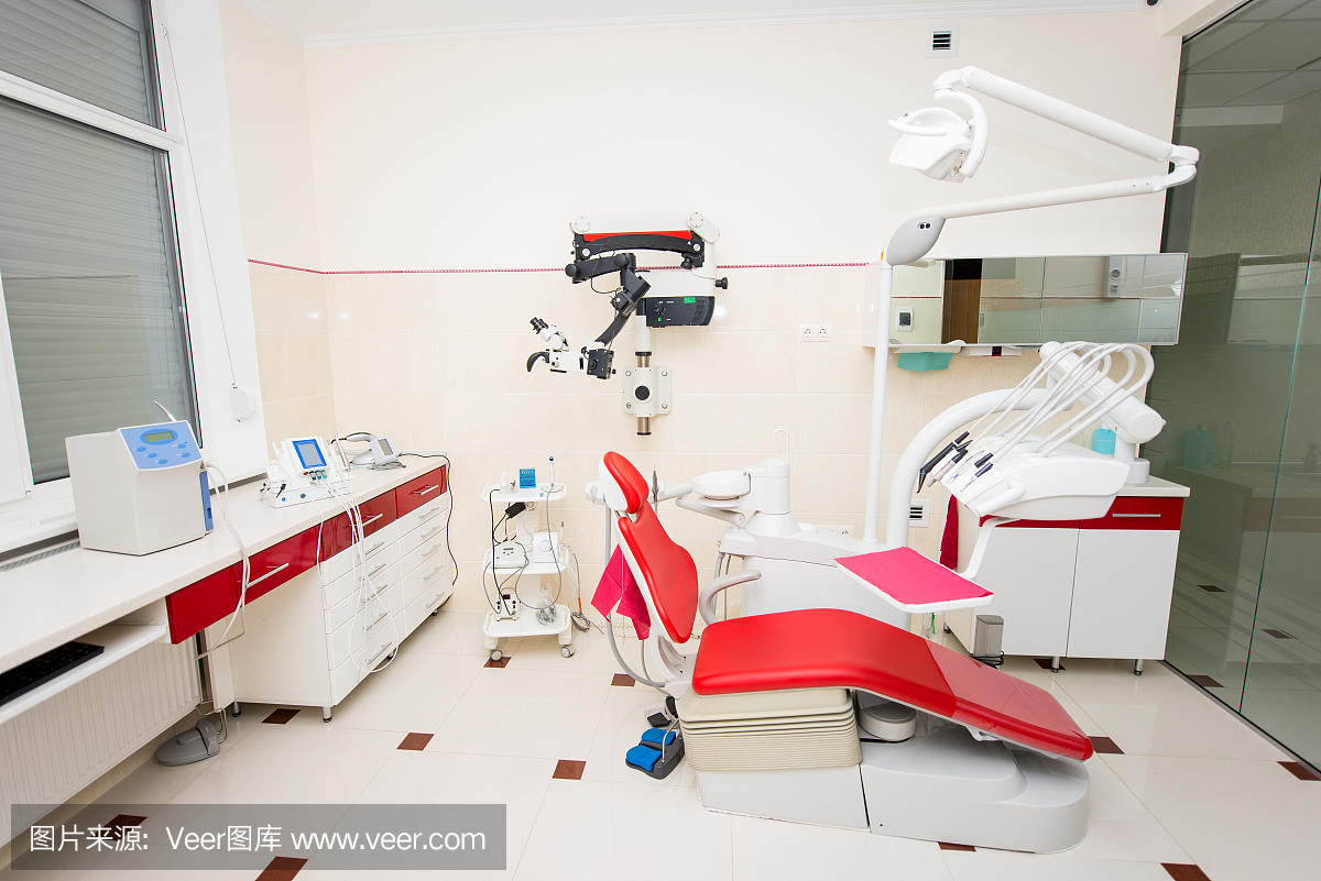带有红色牙医椅子和牙科设备的牙医办公室,包