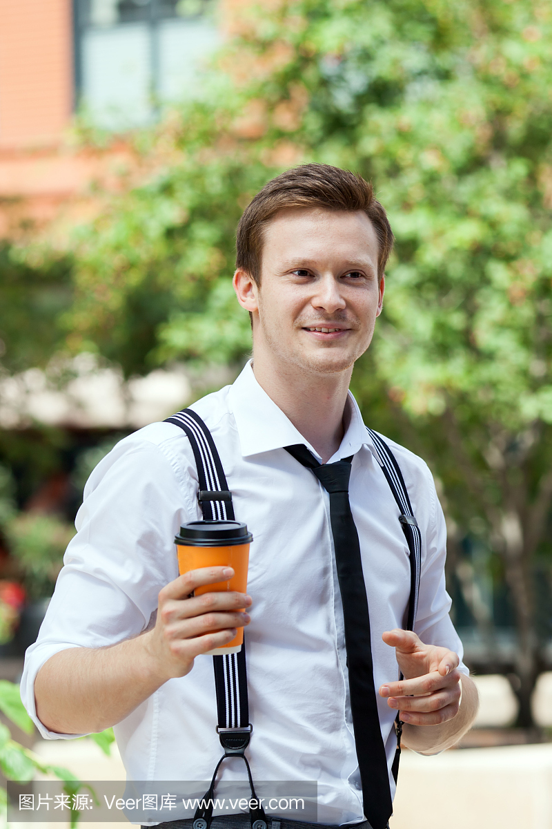 有盖帽的咖啡在街道上的年轻人