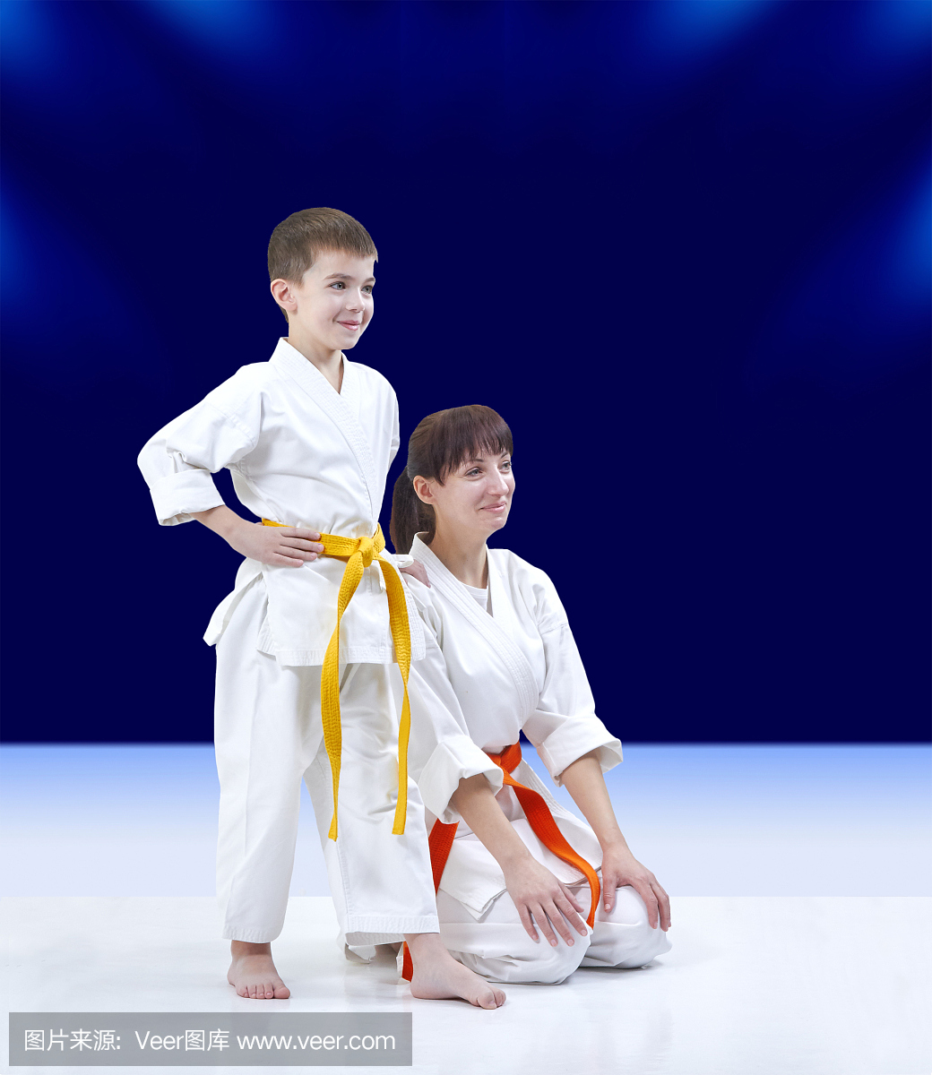 在深蓝色的背景母亲和儿子在karategi