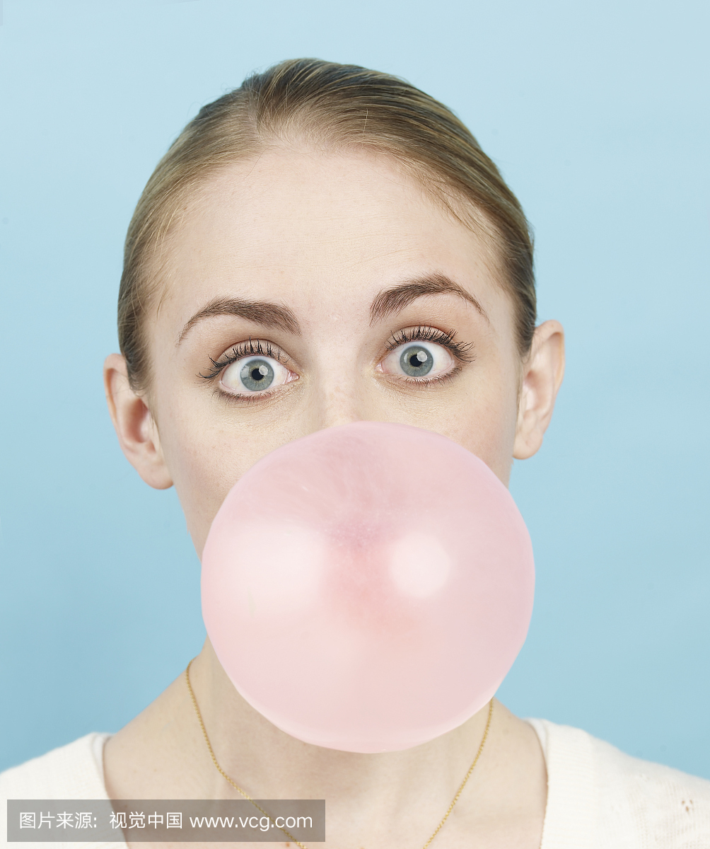 吹粉红色泡泡糖泡沫,肖像的年轻女子