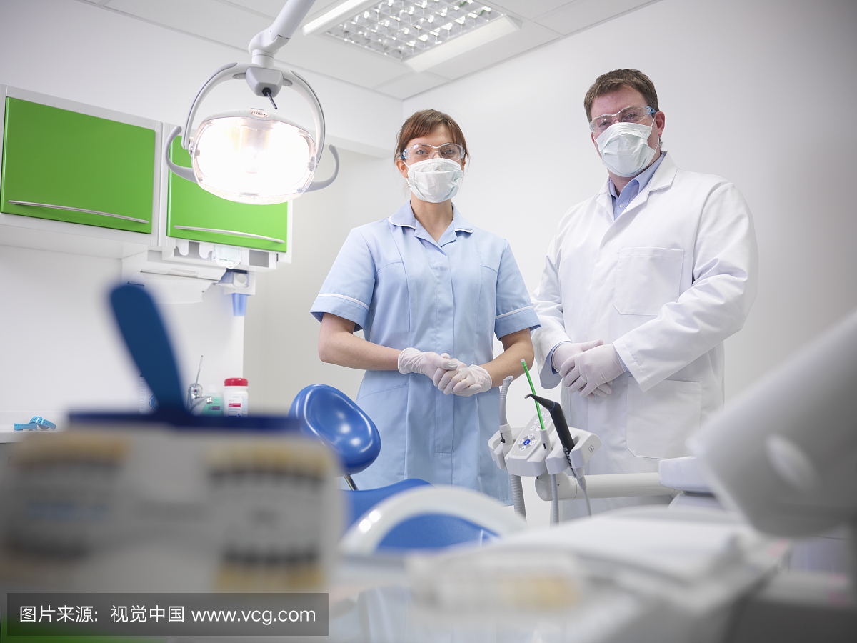 牙医和学徒在牙科手术中戴安全眼镜和面罩