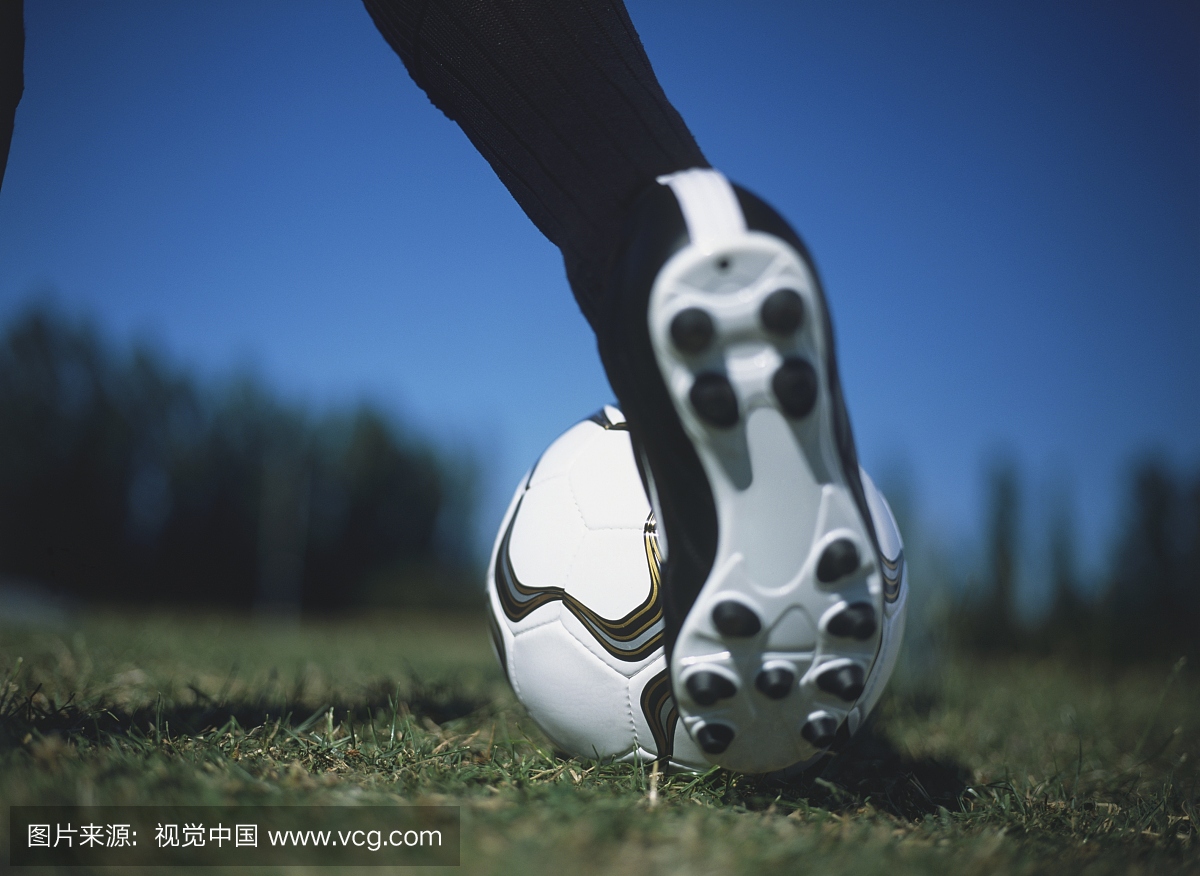 足球被踢在草坪上,特写。