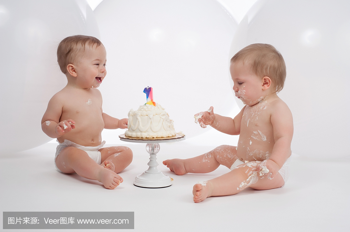 一岁的双胞胎男孩与生日蛋糕