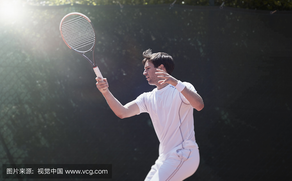 年轻的男网球运动员打网球,挥舞着网球拍