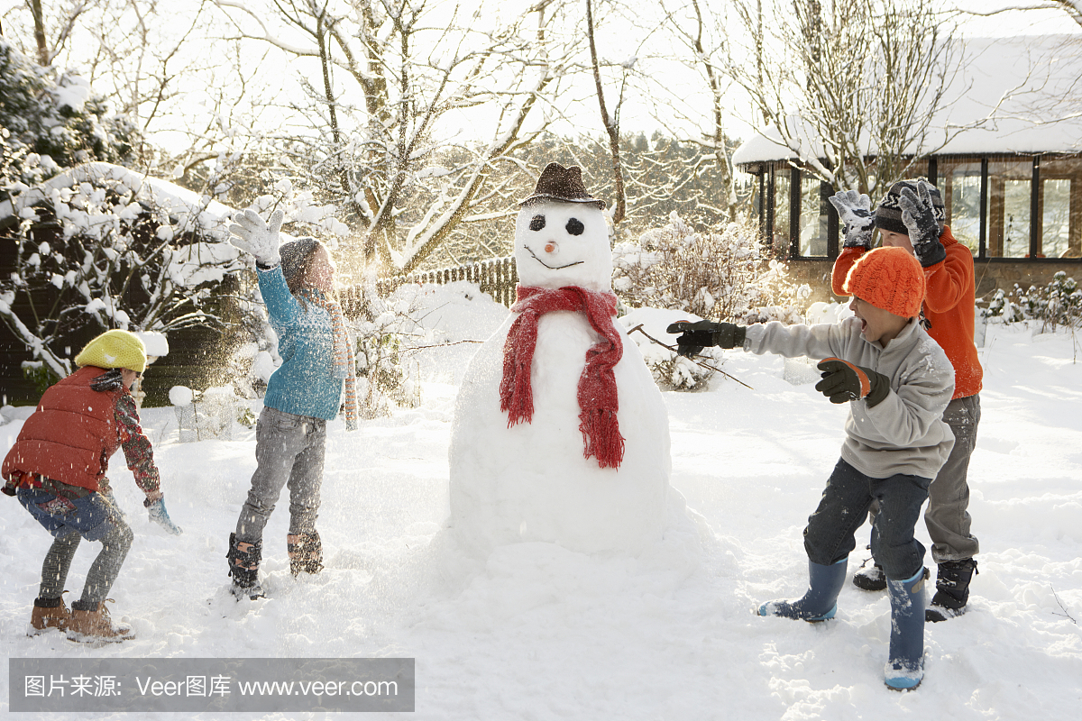 孩子们建立一个雪人,并有一个雪球战斗