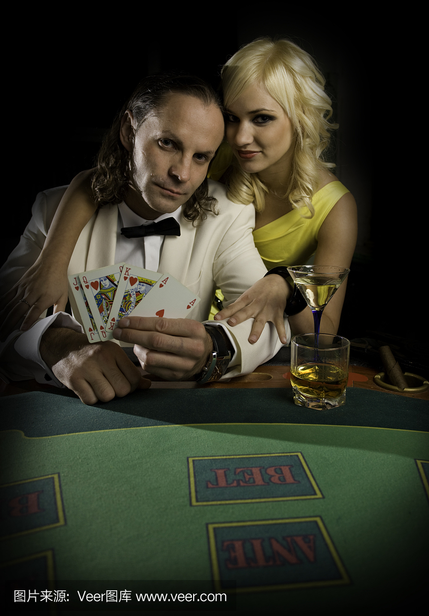 男子与年轻的金发女子在他旁边赌博