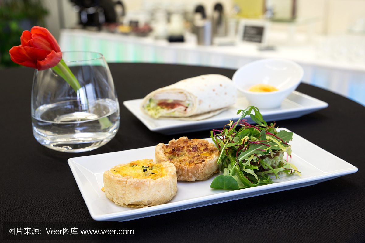 两个qu hes和鸡肉玉米饼包裹在现代板块上。