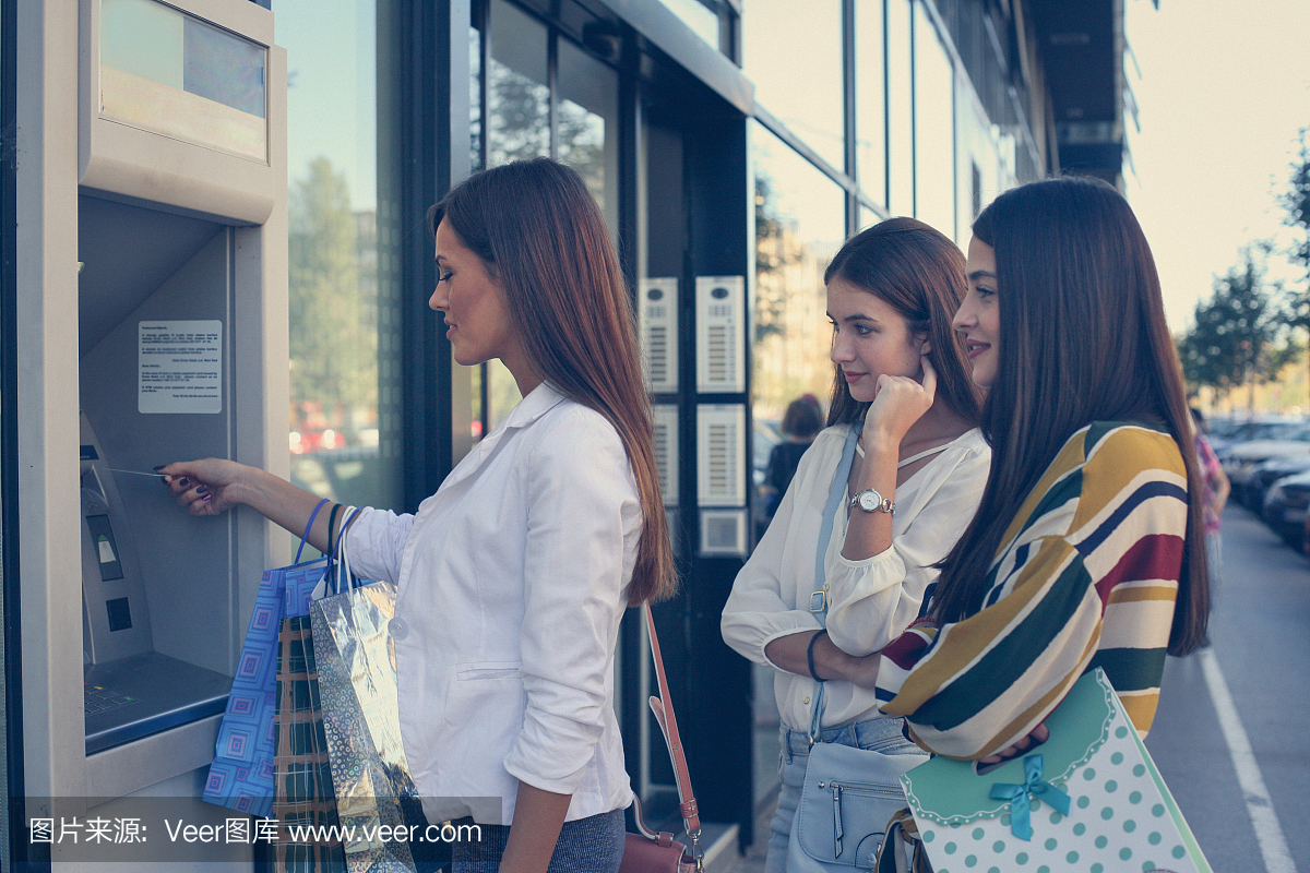 Young woman with friends take money from cas