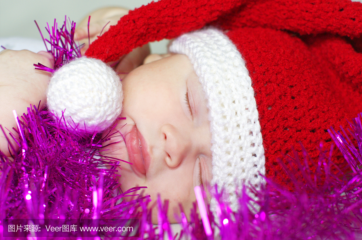 睡觉的宝宝在新年的帽子上等待礼物