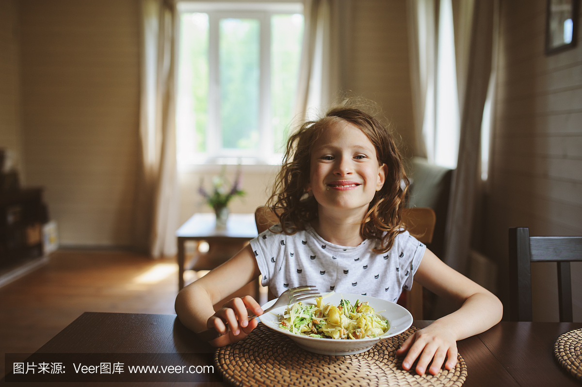 8岁快乐的小孩女孩在家吃午餐或晚餐的面食