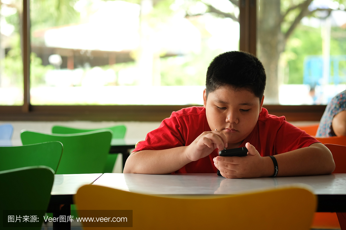 亚洲孩子男孩上瘾玩平板电脑和手机,游戏成瘾