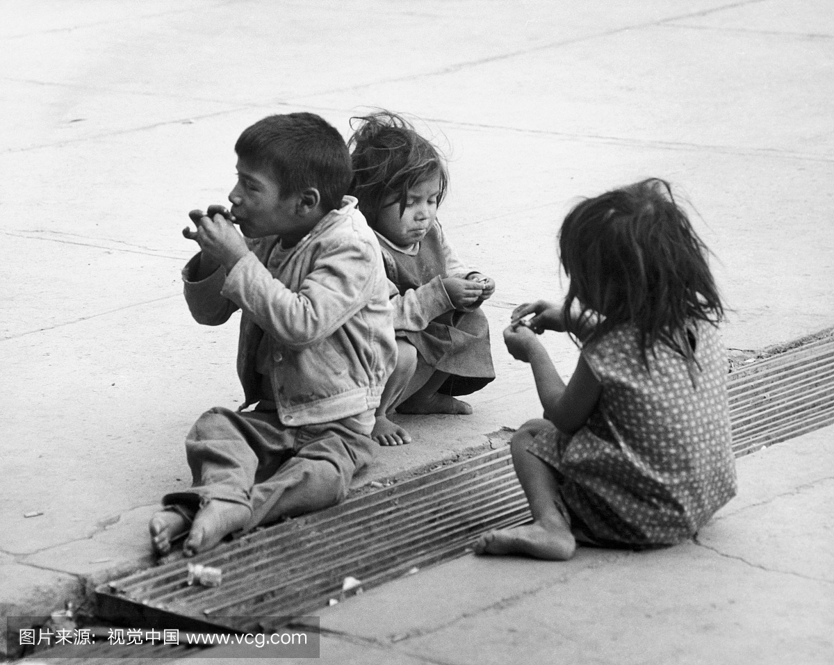 男孩和两个女孩坐在路上,墨西哥