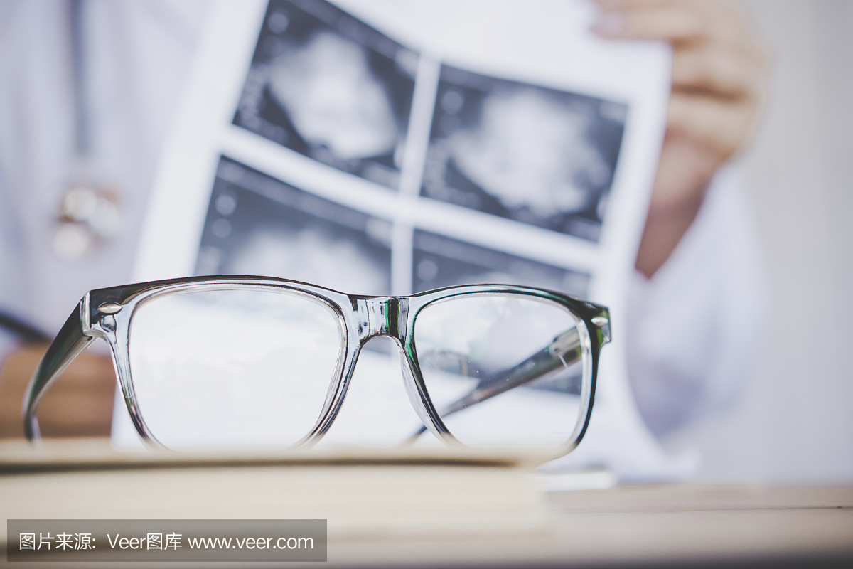 在桌上的眼镜有医院办公室工作的医生模糊背景