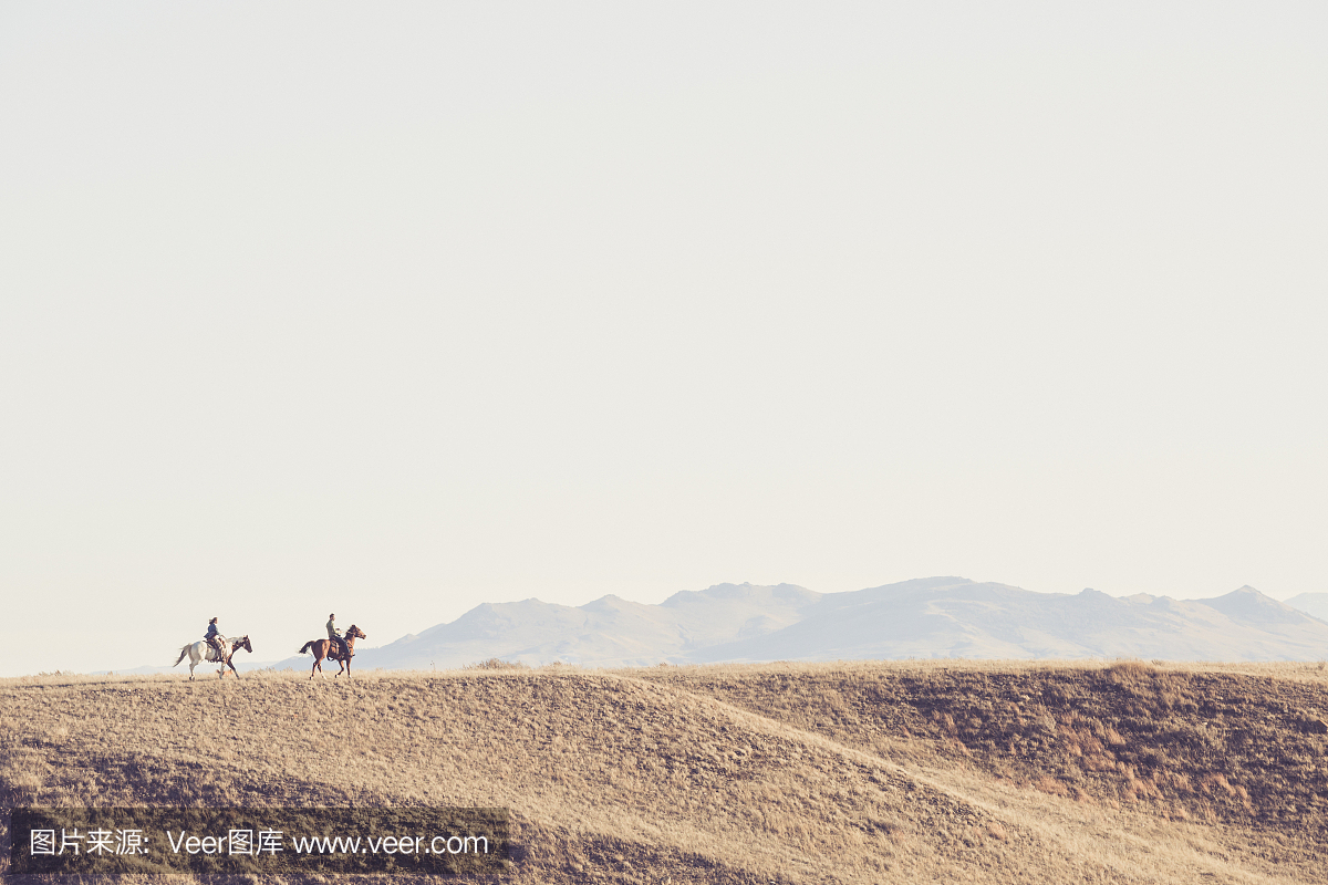 男子和女子骑马在蒙大拿州风景