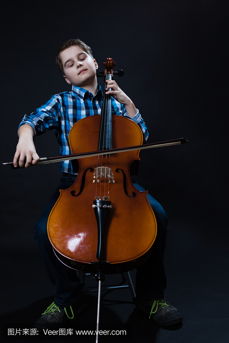 年轻的大提琴家在大提琴上演奏古典音乐