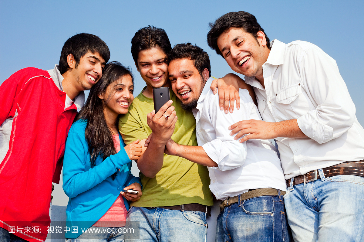 年轻的印度朋友人们阅读分享短信笑话手机
