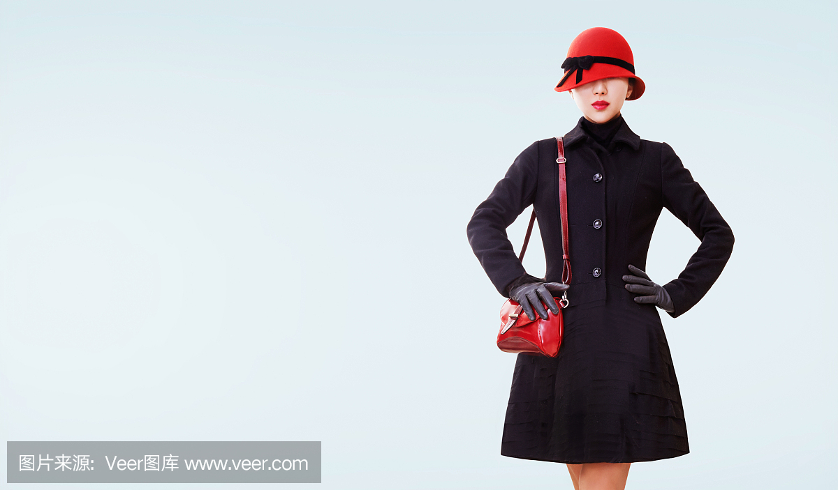 冬天时尚看。红帽子,钱包和黑色外套隔离。