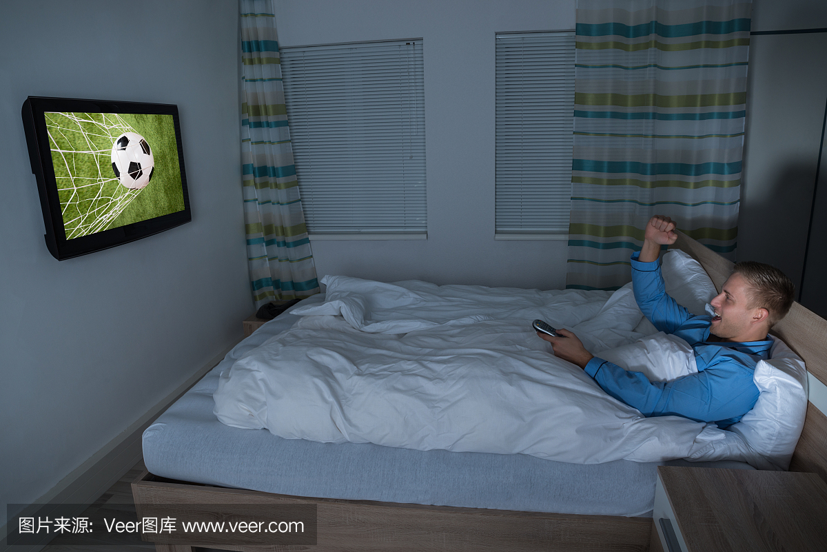男子在电视上看足球比赛