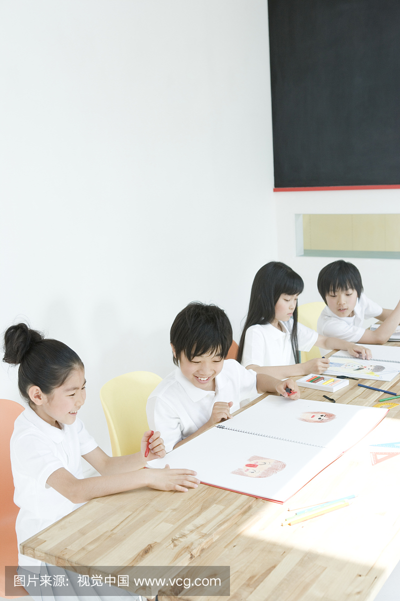 男孩和女孩(6-9岁)在桌上绘制图片,高角度视图