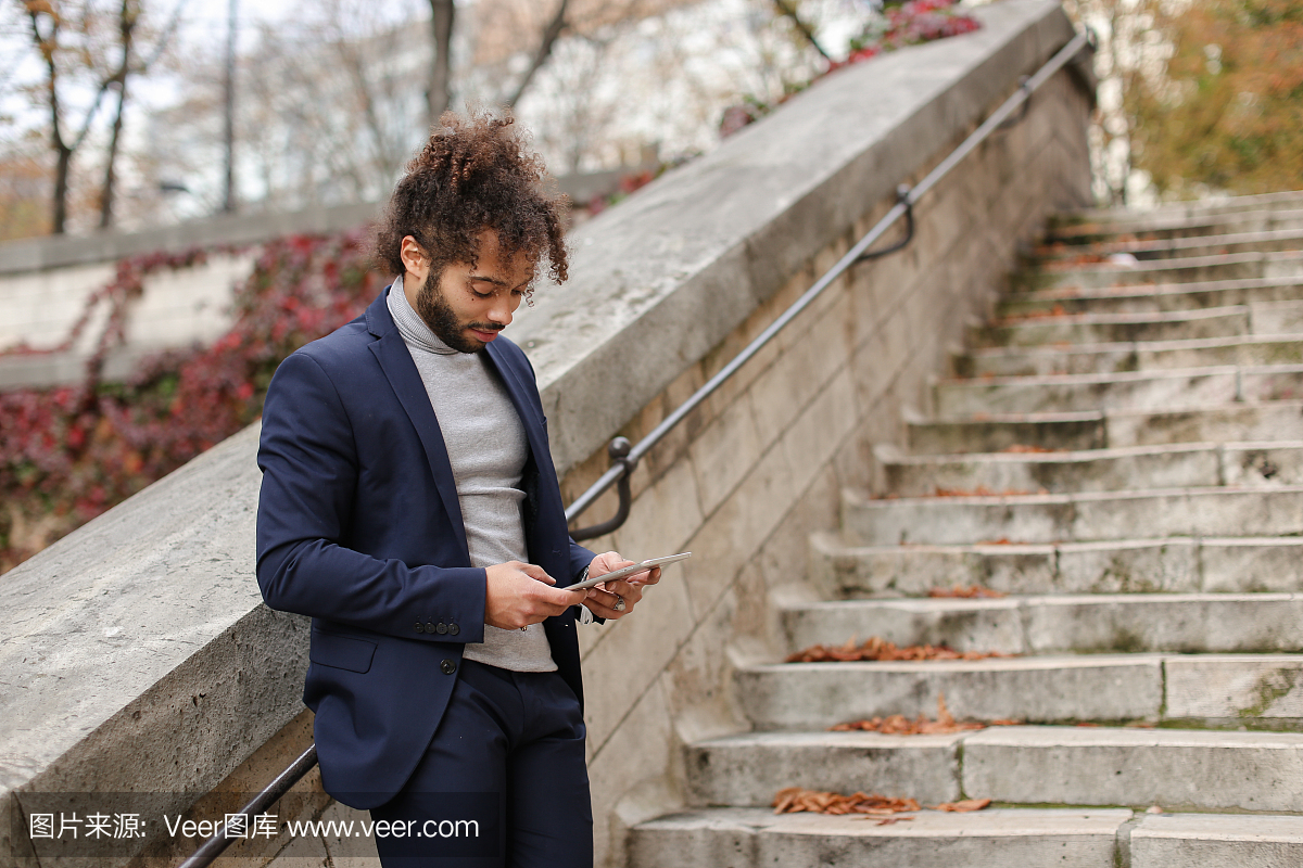 英俊的一半奈及利亚男孩住在平板电脑上,看着