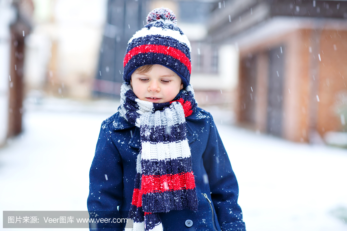 可爱的小有趣的孩子男孩在多彩的冬季时尚服装