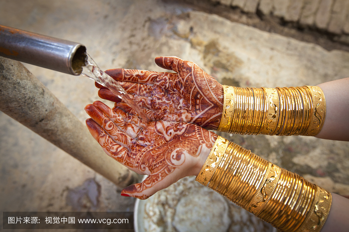 喷出的水倒入用mehndi覆盖的手掌; ludhiana p