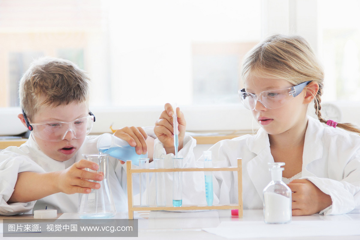 穿实验室外套的孩子正在用烧瓶和试管进行实验