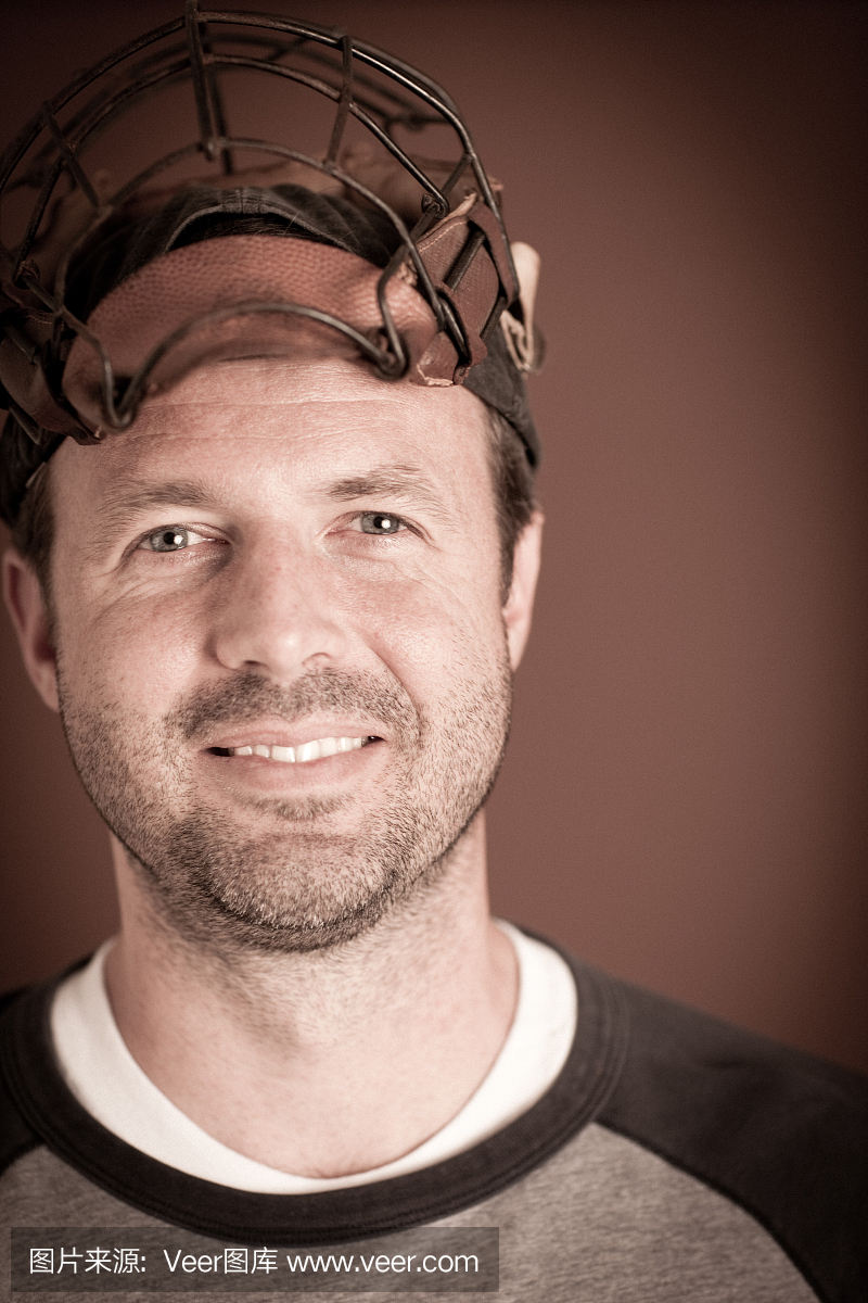 复古棒球运动员穿着捕手的面具和看相机