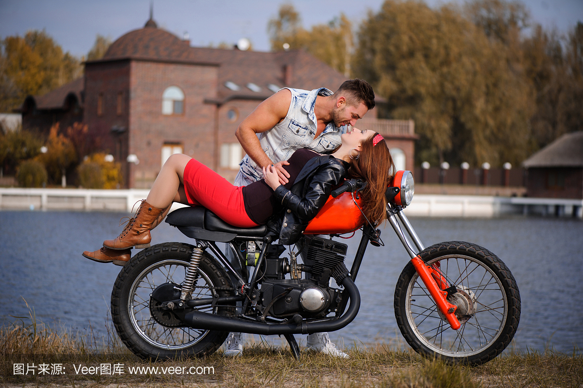 时尚和新潮夫妇在爱情上躺着的摩托车调情特写