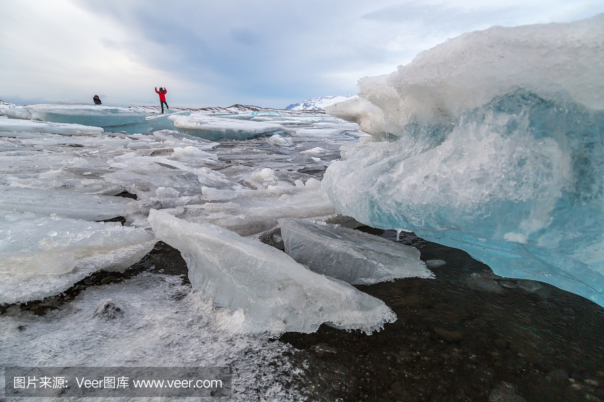 两个人在冰岛Jokulsarlon泻湖冰上摆放