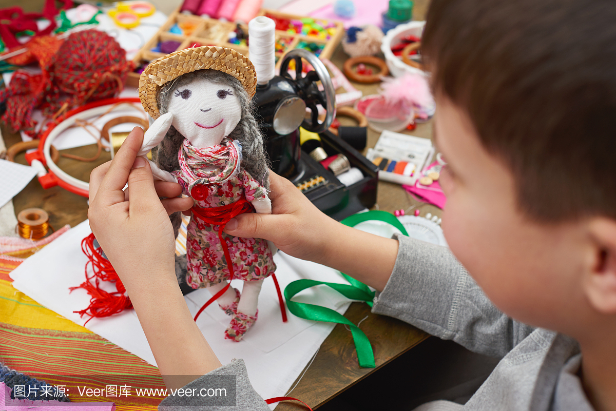 男孩裁缝学习缝纫,穿着娃娃,手工制作和工艺品