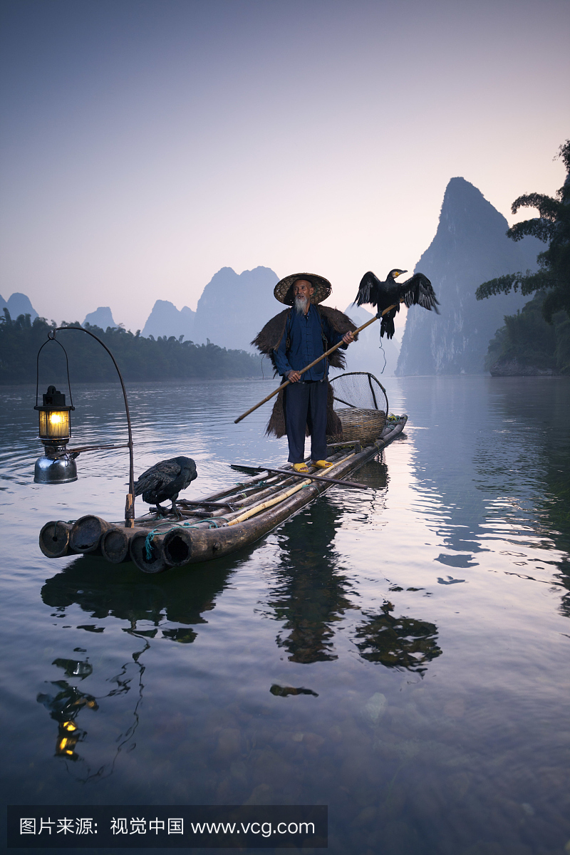 中国,关西,阳朔。老中国渔夫在日出在漓江,钓鸬