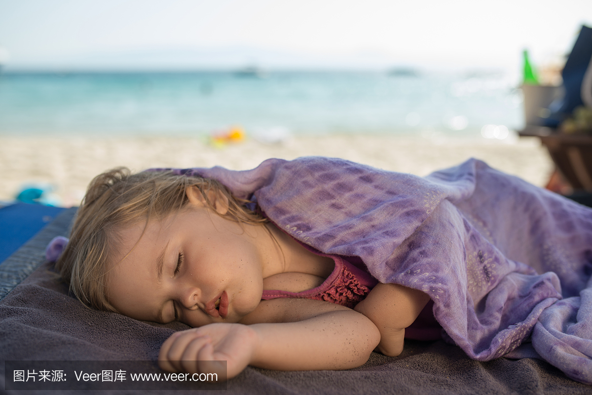 可爱的小宝宝在沙滩上睡觉,躺在毛巾上