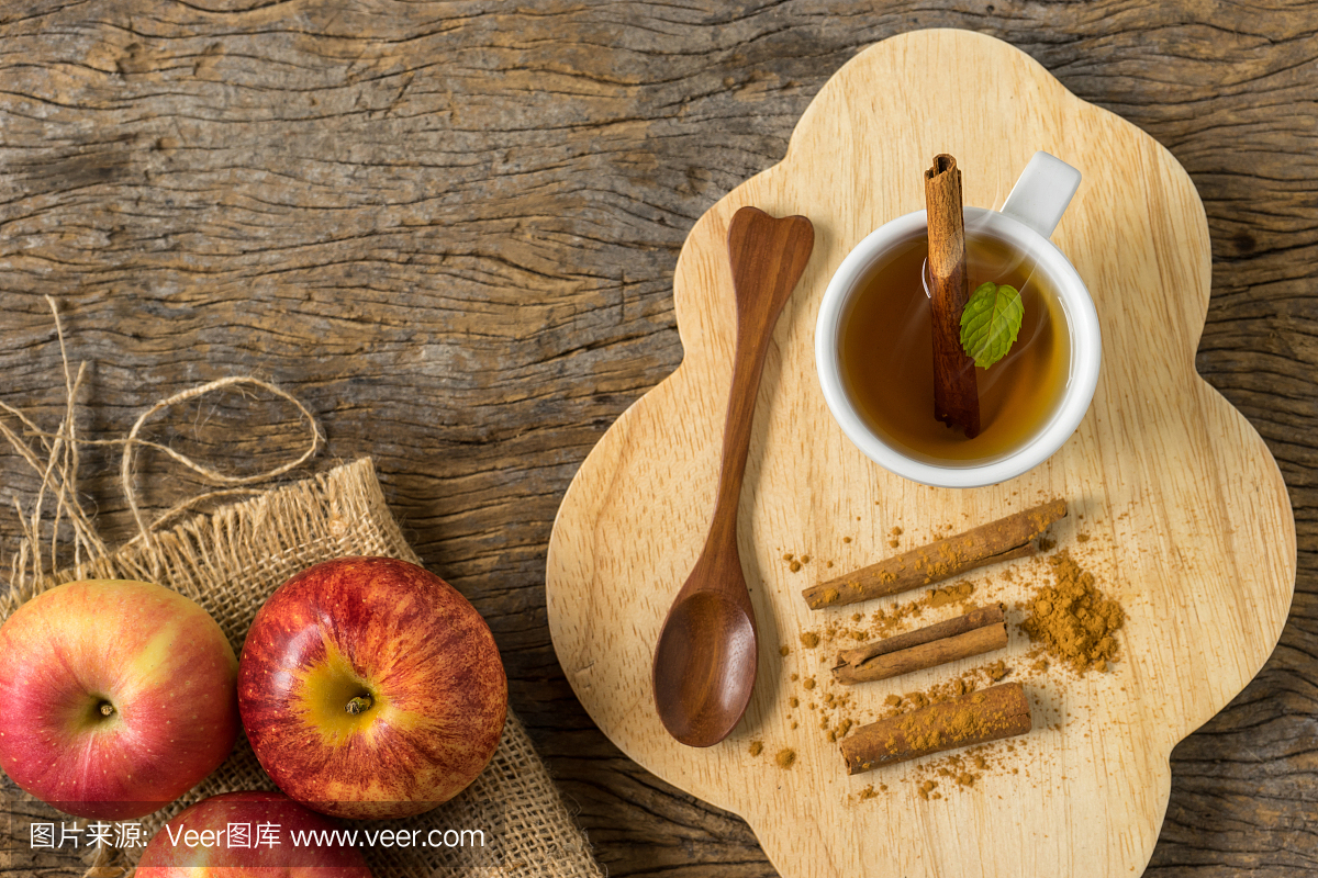 顶视图热杯苹果汁在肉桂和肉桂粉在旧木头上。