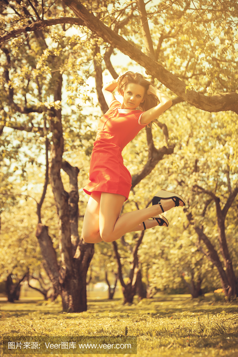 美丽的年轻女子跳上公园