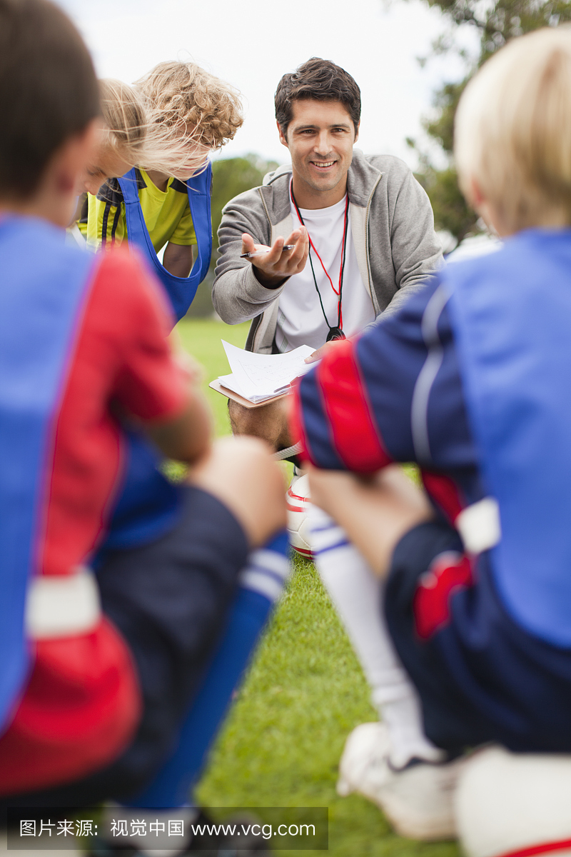 教练与儿童足球队交谈