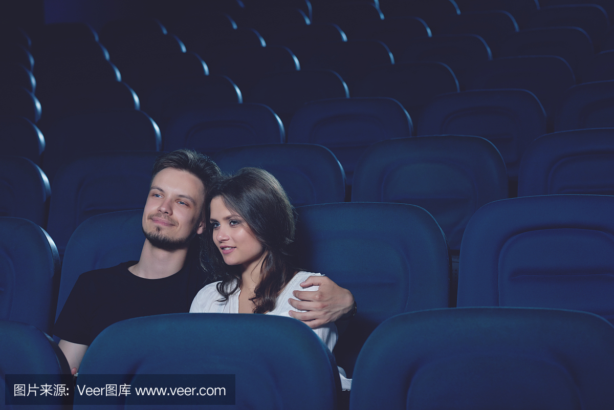 情侣拥抱,独自一人坐在电影院里。